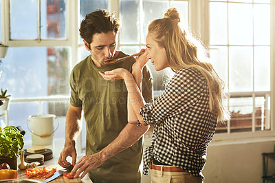 Buy stock photo Shot of a young couple preparing a meal together at home
