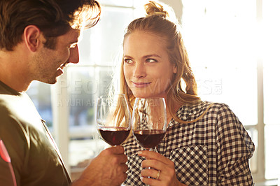 Buy stock photo Shot of a young couple toasting with wine at home