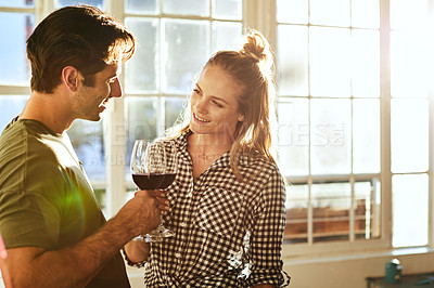 Buy stock photo Shot of a young couple toasting with wine at home
