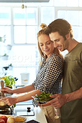 Buy stock photo Shot of a young couple preparing a meal together at home