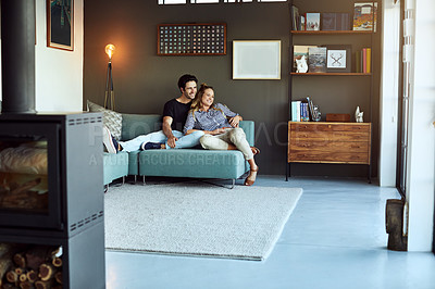 Buy stock photo Shot of a happy young couple relaxing together on the sofa at home