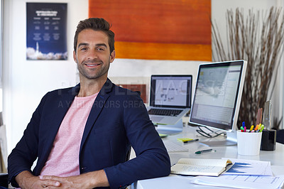 Buy stock photo Shot of a handsome young man sitting in his office