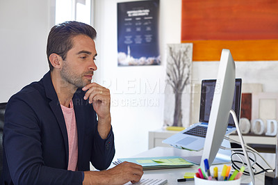 Buy stock photo Shot of a handsome young man sitting in his office