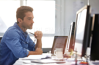 Buy stock photo Shot of a handsome young man working in an office