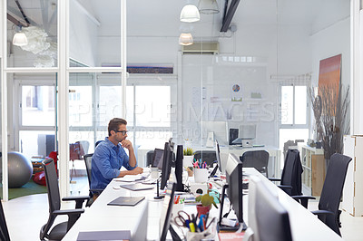 Buy stock photo Shot of a handsome young man working in an office