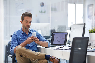 Buy stock photo Cropped shot of a young man using his cellphone in his office