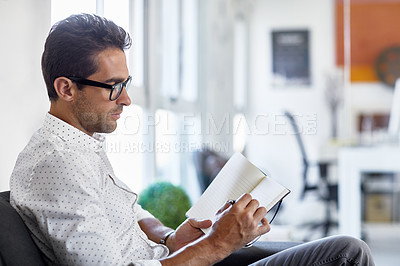 Buy stock photo Shot of a young businessman working in his office