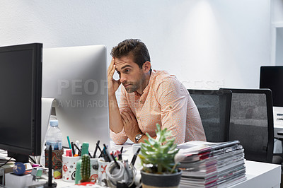 Buy stock photo Shot of a businessman looking exhausted while sitting at his desk