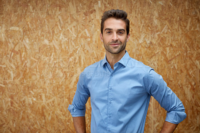 Buy stock photo Cropped shot of a handsome young man posing against a wooden wall