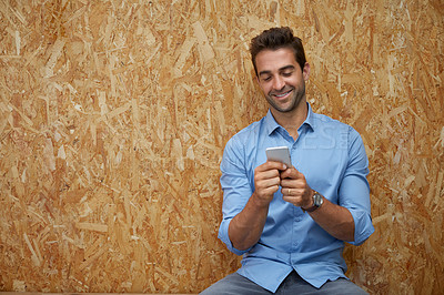 Buy stock photo Cropped shot of a handsome young man posing against a wooden wall