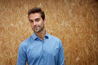 Buy stock photo Cropped shot of a handsome young man posing against a wooden wall