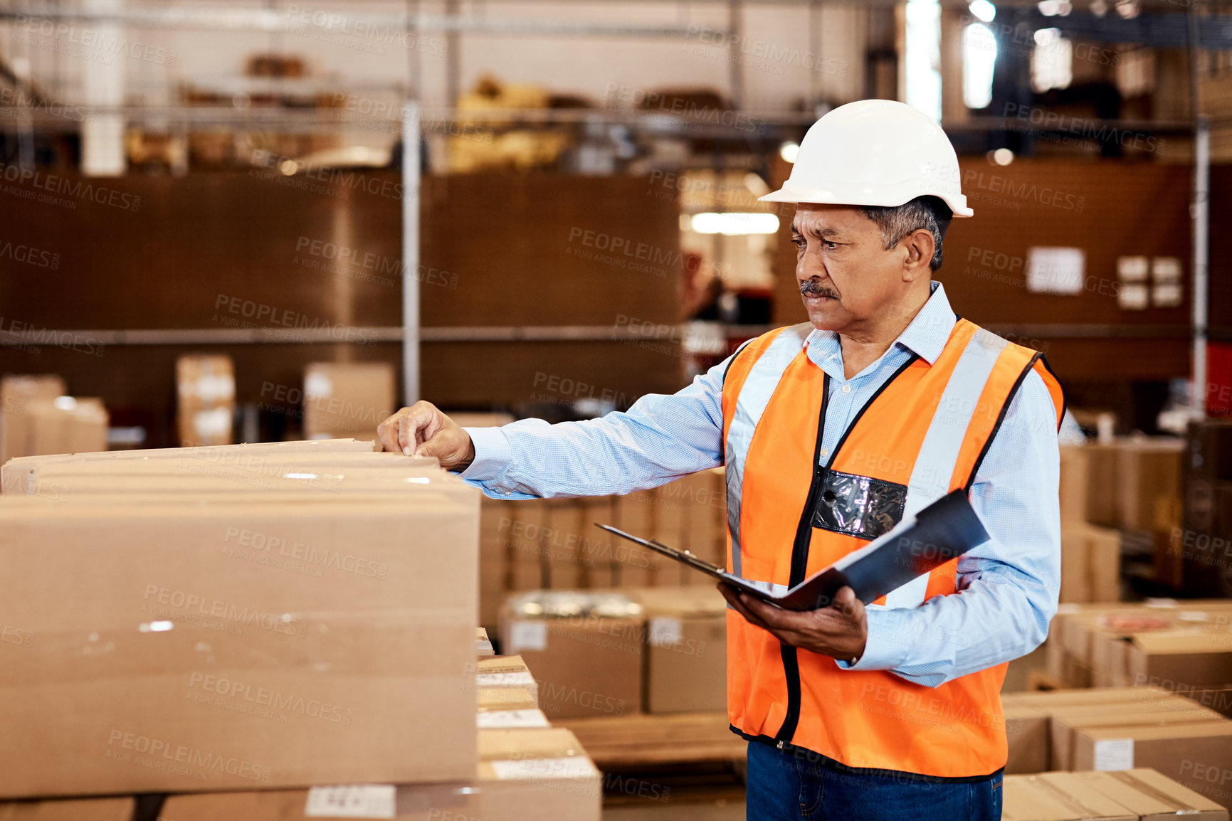 Buy stock photo Shot of a mature man doing inspections in a warehouse