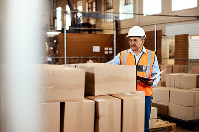 Buy stock photo Shot of a mature man doing inspections in a warehouse