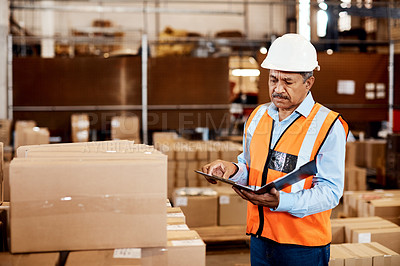 Buy stock photo Shot of a mature man doing inspections in a warehouse