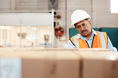 Buy stock photo Shot of a mature man doing inspections in a warehouse