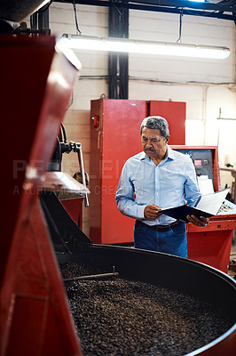 Buy stock photo Shot of a mature man overseeing the production process in a coffee distribution warehouse