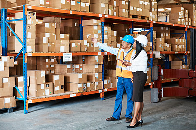 Buy stock photo Shot of a mature man and woman using a digital tablet while working together in a warehouse