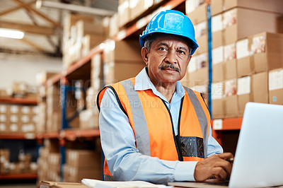 Buy stock photo Shot of a mature man using a laptop while working in a warehouse