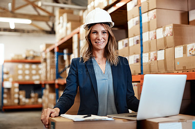 Buy stock photo Shot of a young woman using a laptop while working in a warehouse