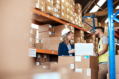 Buy stock photo Shot of a young man and woman using a laptop while working together in a warehouse