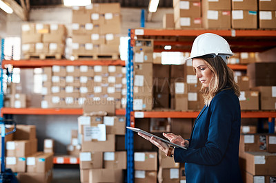 Buy stock photo Shot of a young woman using a digital tablet while working in a warehouse
