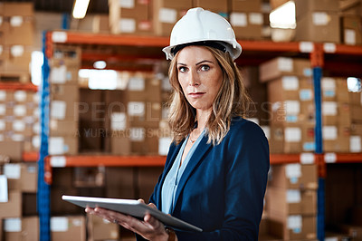 Buy stock photo Shot of a young woman using a digital tablet while working in a warehouse