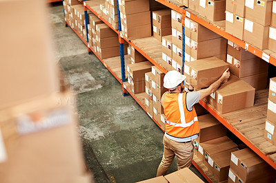 Buy stock photo High angle shot of a young man working in a warehouse