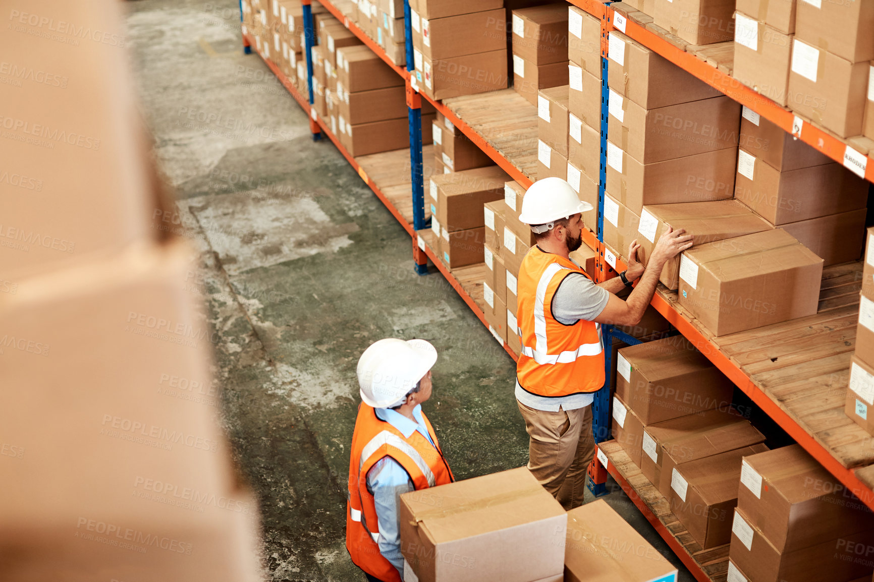 Buy stock photo High angle shot of two men working in a warehouse