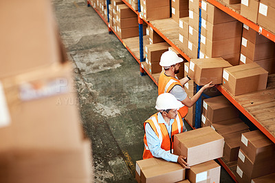 Buy stock photo High angle shot of two men working in a warehouse