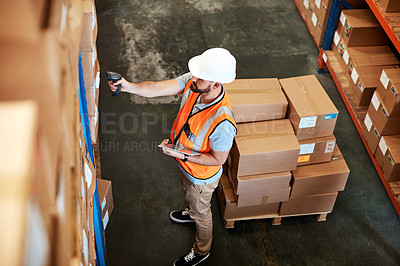 Buy stock photo High angle shot of a young man using a barcode reader and digital tablet in a warehouse