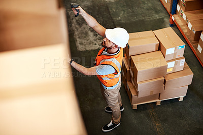 Buy stock photo High angle shot of a young man using a barcode reader in a warehouse