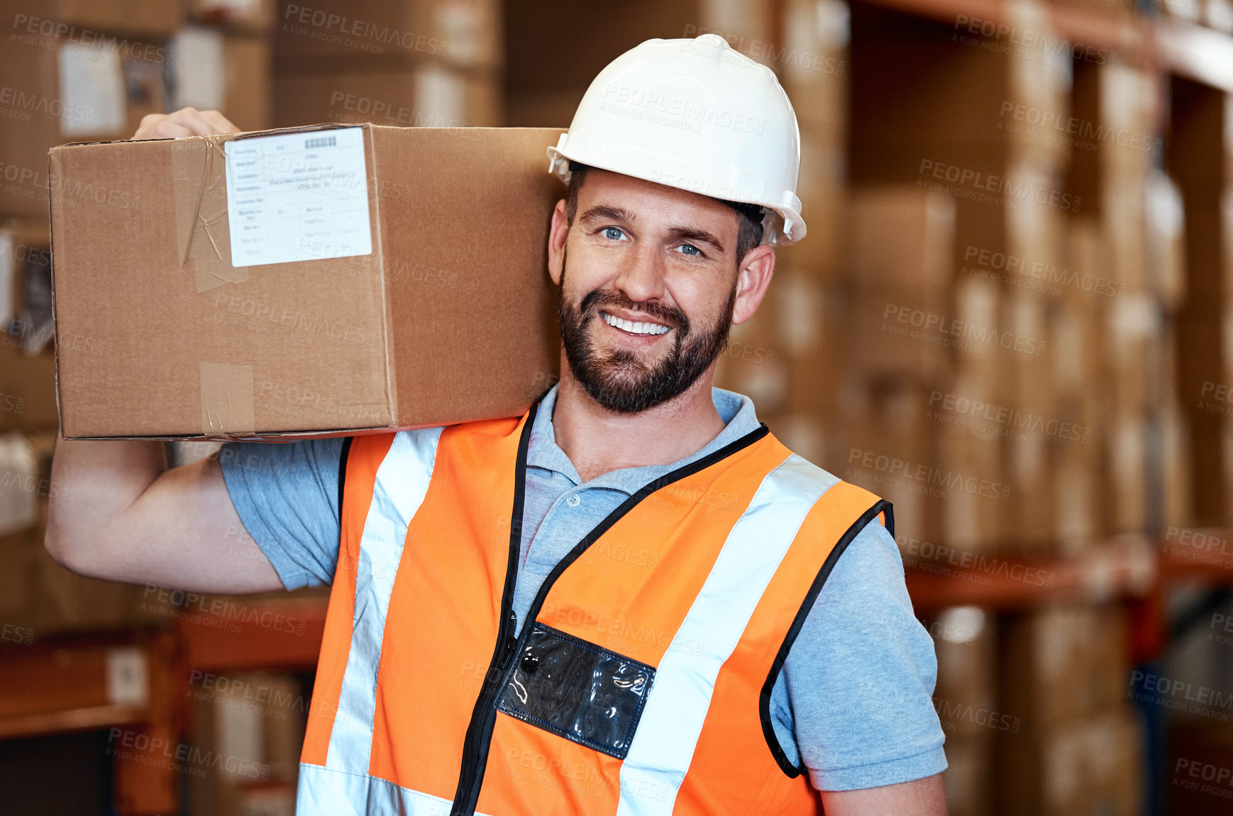 Buy stock photo Portrait of a young man holding a box while working in a warehouse