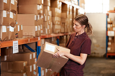Buy stock photo Shot of a young woman working in a warehouse