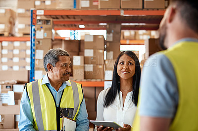 Buy stock photo Shot of a group of factory workers having a discussion in a warehouse