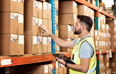 Buy stock photo Shot of a young man using a clipboard while working in a warehouse