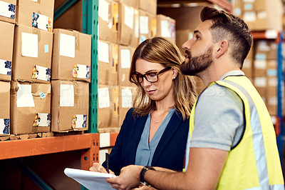 Buy stock photo Shot of a young man and woman working together in a warehouse