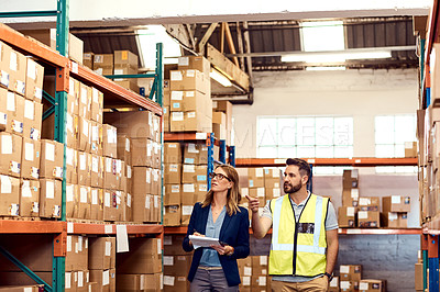 Buy stock photo Shot of a young man and woman working together in a warehouse