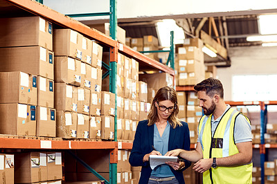 Buy stock photo Shot of a young man and woman working together in a warehouse