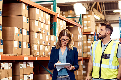 Buy stock photo Shot of a young man and woman working together in a warehouse