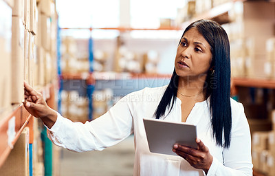 Buy stock photo Shot of a mature factory manager using a digital tablet in a warehouse