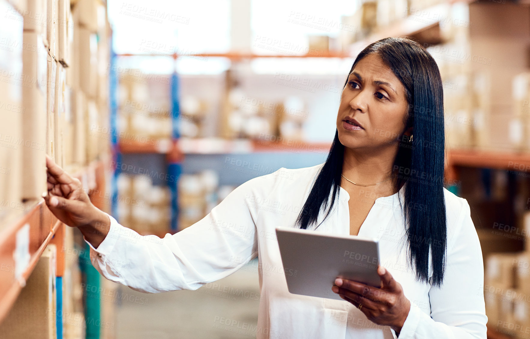 Buy stock photo Shot of a mature factory manager using a digital tablet in a warehouse