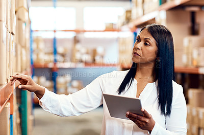 Buy stock photo Shot of a mature factory manager using a digital tablet in a warehouse