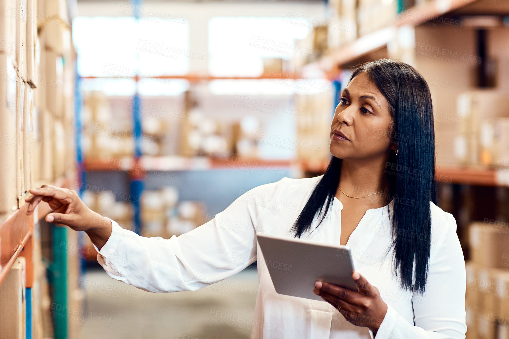 Buy stock photo Shot of a mature factory manager using a digital tablet in a warehouse