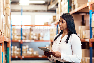 Buy stock photo Shot of a mature factory manager using a digital tablet in a warehouse