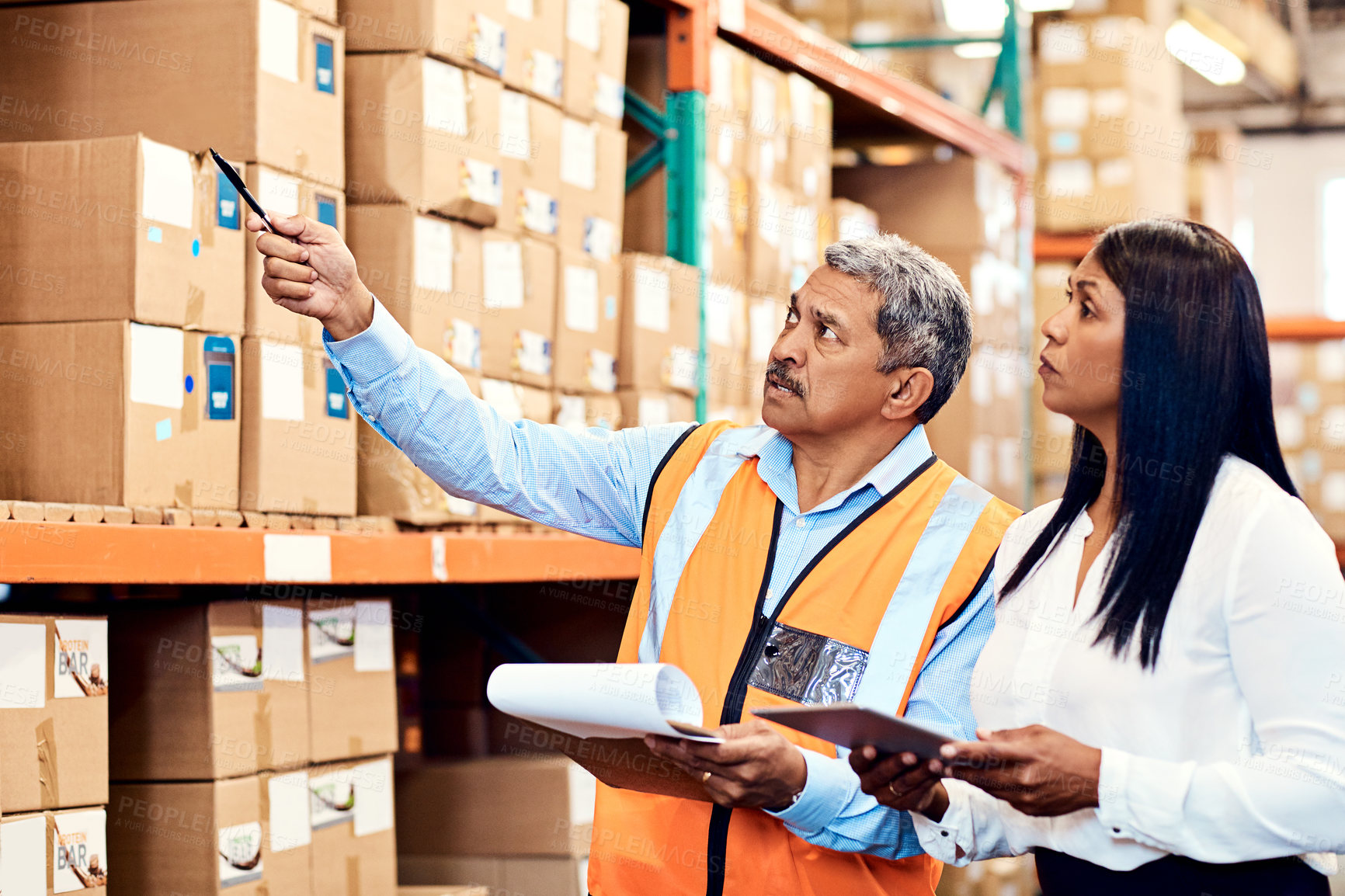 Buy stock photo Shot of a mature man and woman working together in a warehouse
