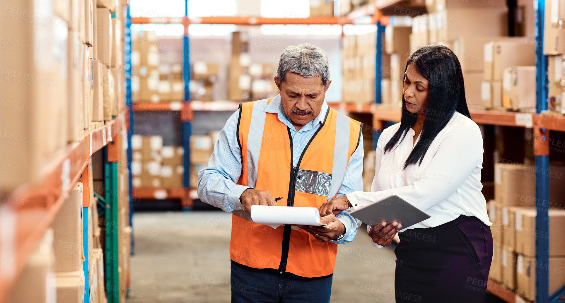 Buy stock photo Shot of a mature man and woman working together in a warehouse