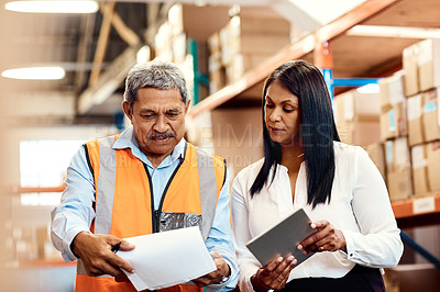 Buy stock photo Shot of a mature man and woman working together in a warehouse