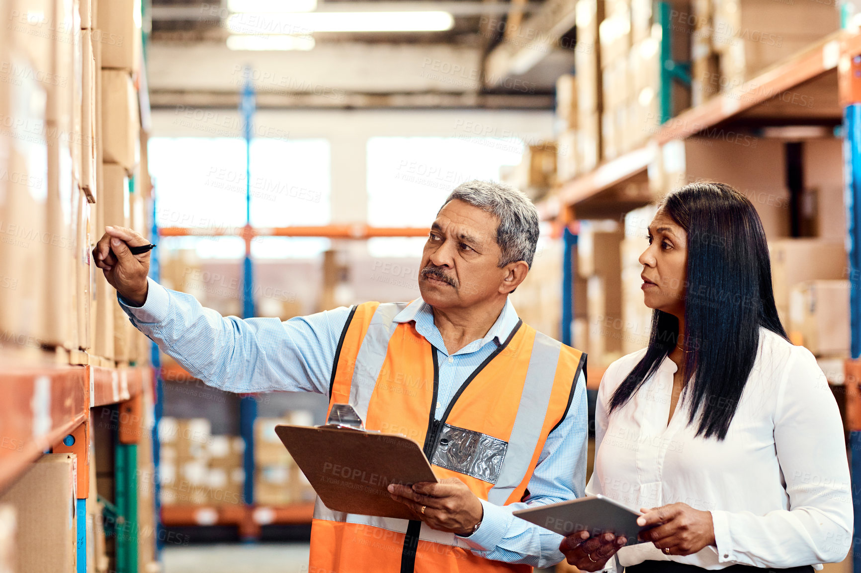 Buy stock photo Shot of a mature man and woman working together in a warehouse