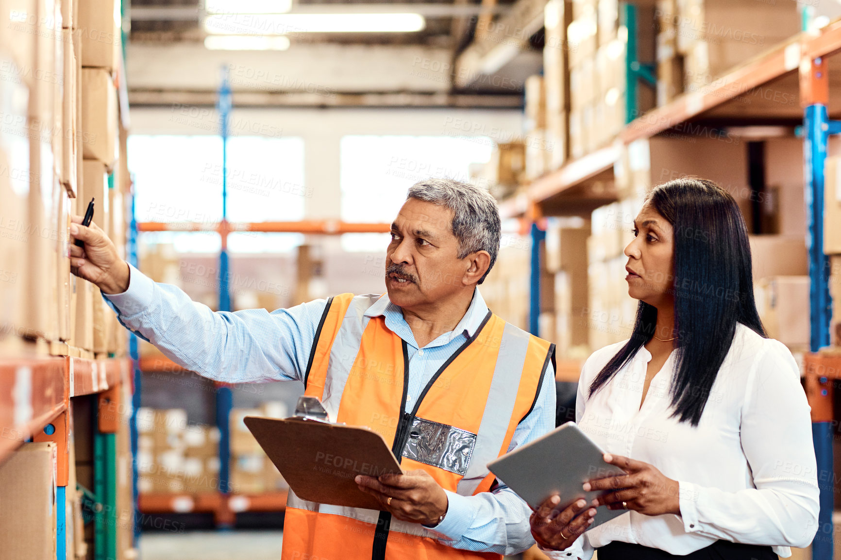 Buy stock photo Shot of a mature man and woman working together in a warehouse