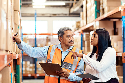 Buy stock photo Shot of a mature man and woman working together in a warehouse